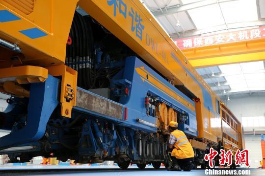 圖為工人正在清理大型養(yǎng)路機械?！堖h 攝